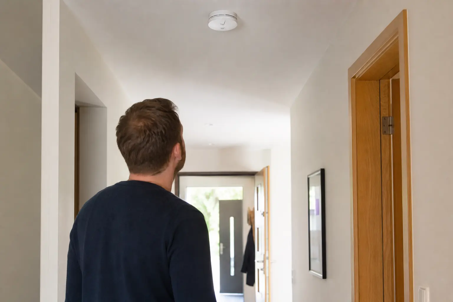 Rauchmelder an der Zimmerdecke während einer ruhigen Wohnsituation ohne sichtbaren Rauch